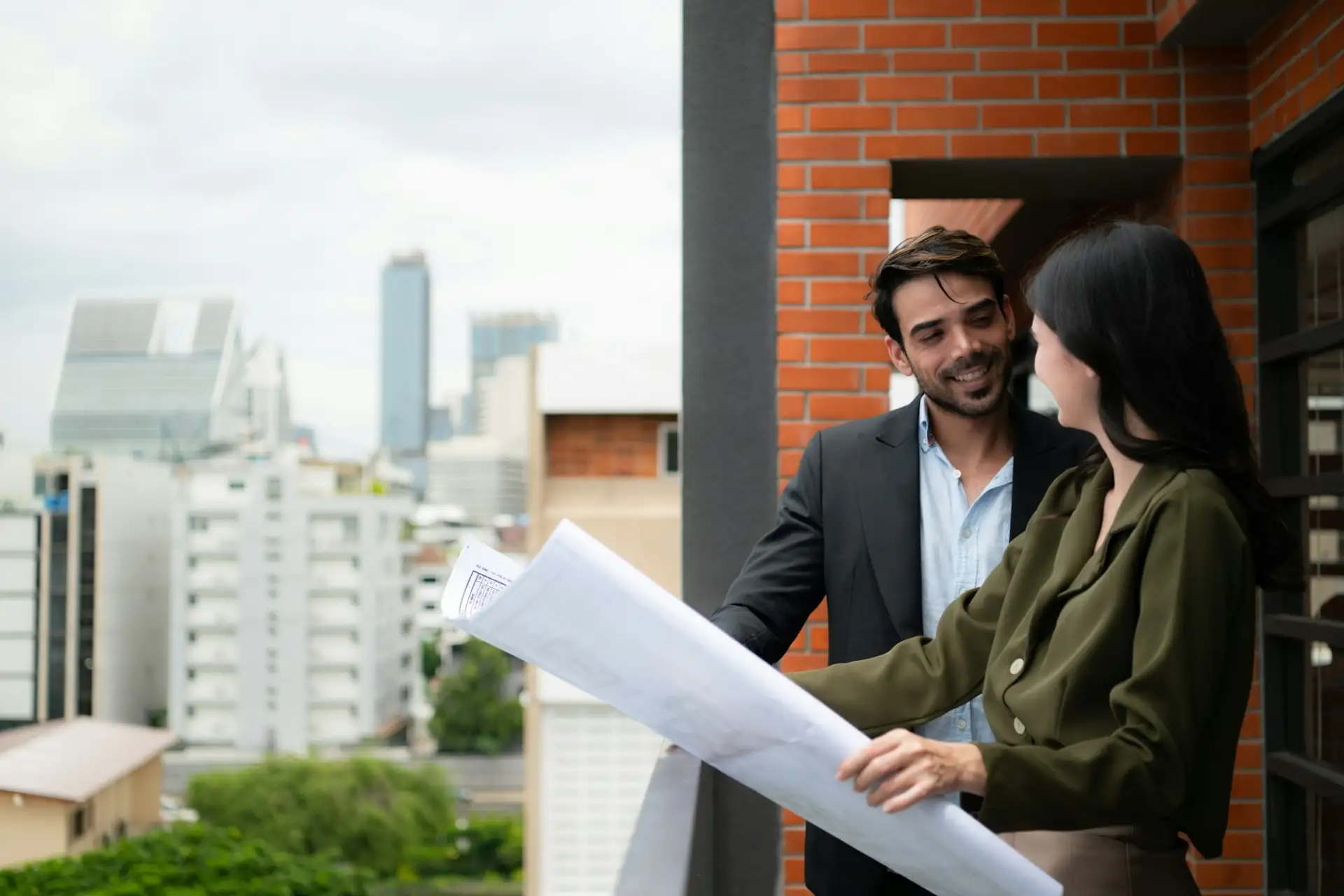 Businessman and businesswoman discussing project on the balcony of office building.